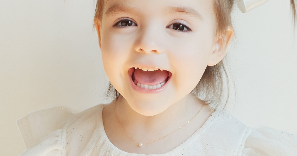 cute toddler girl wearing her Add A Pearl necklace