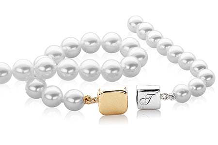 Two pearl strands with gold and silver clasps on a white background