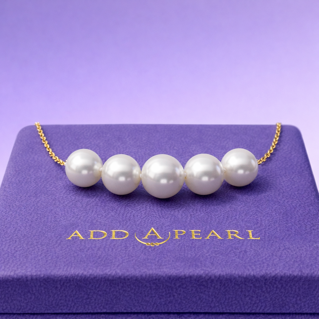 five pearls on a necklace on top of a box