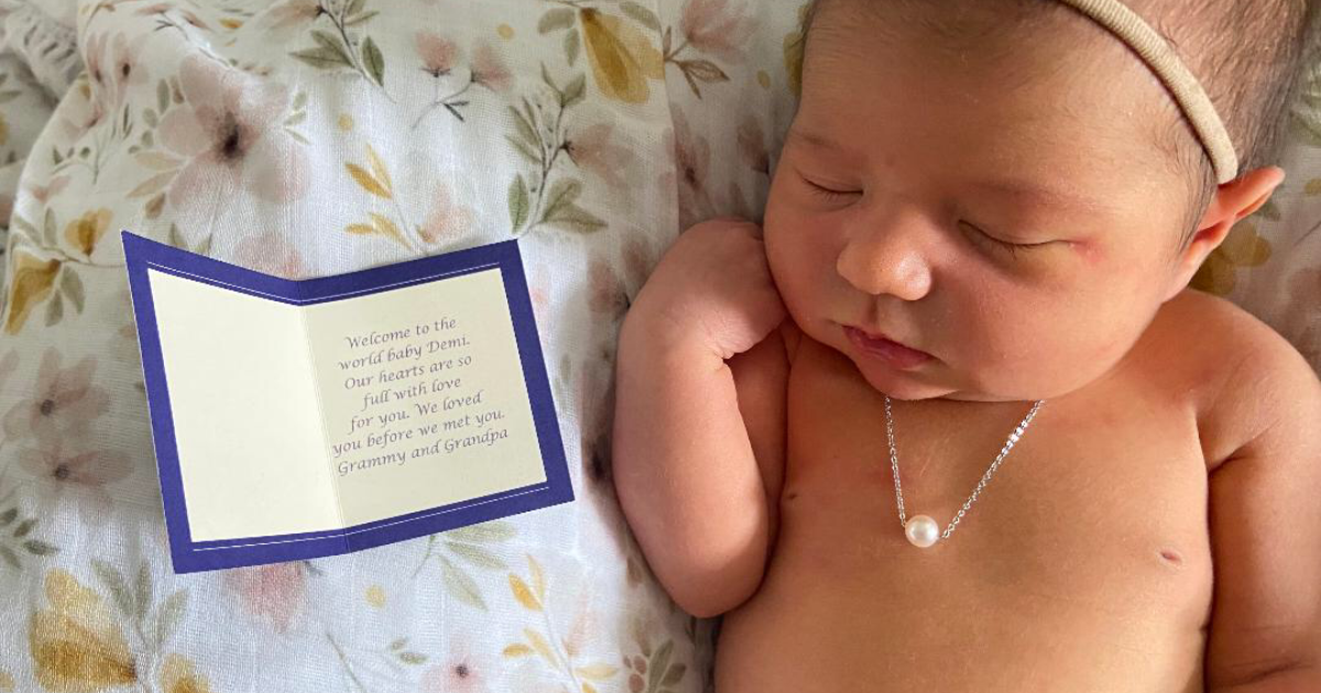 Newborn baby girl wearing her Add A Pearl necklace
