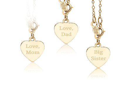 Three gold heart-shaped pendants with engraved text on a white background