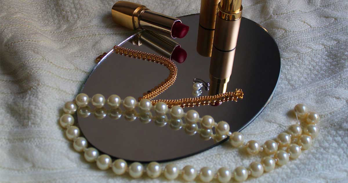 Pearls and lipstick on a mirror