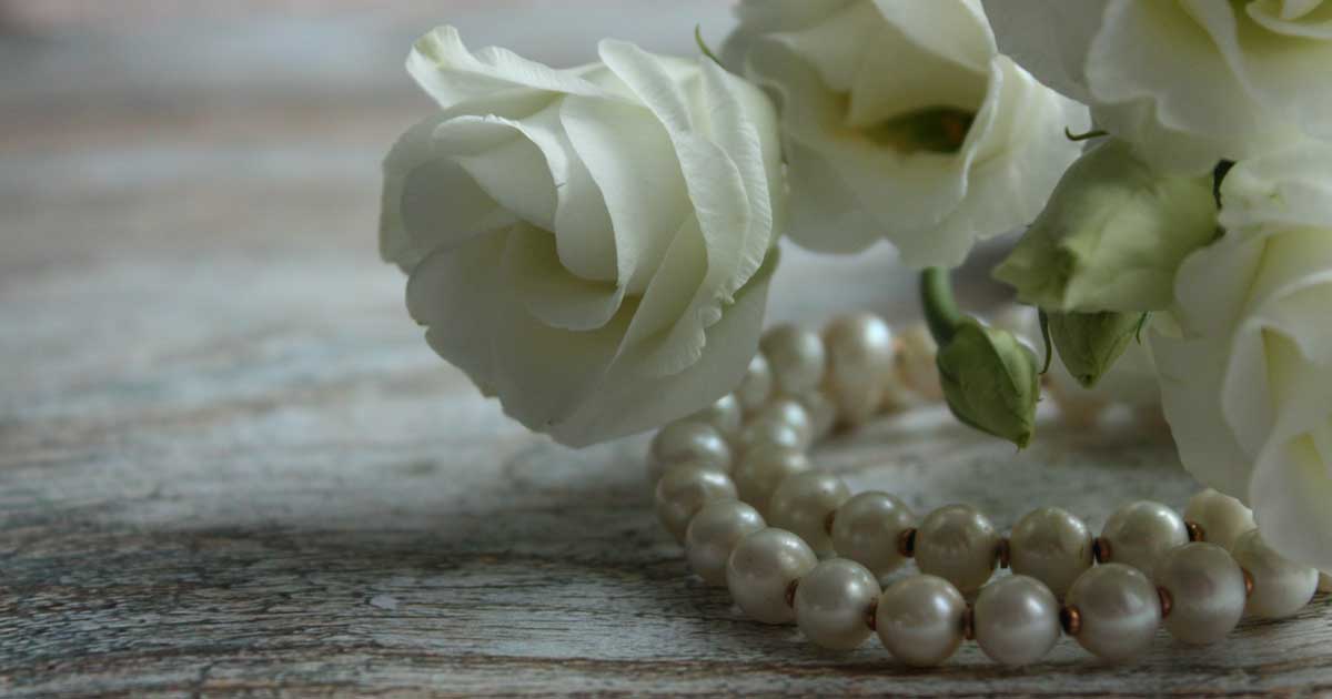 Pearls and white roses on a table
