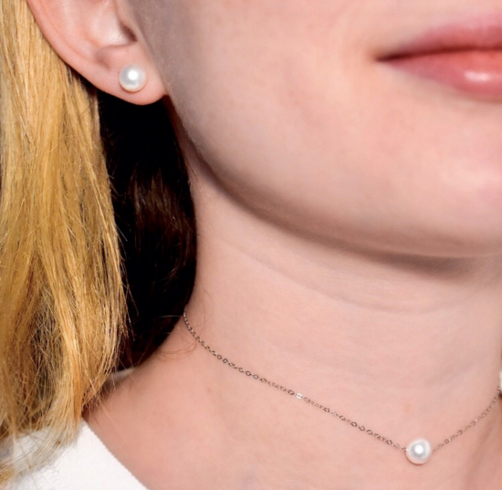 pretty girls face and neck shown wearing a single pearl necklace